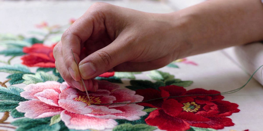 Traditional Chinese hand embroidery detail with peony flowers, artisan at work banner