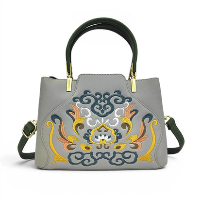 Grey leather handbag with elaborate traditional Chinese floral scroll embroidery, dark green top handle & detachable shoulder strap, polished gold metal hardware, studio shot on plain white background