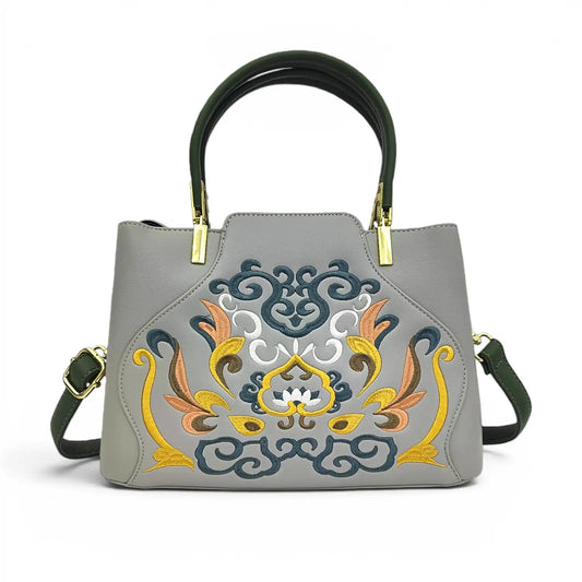 Grey leather handbag with elaborate traditional Chinese floral scroll embroidery, dark green top handle & detachable shoulder strap, polished gold metal hardware, studio shot on plain white background