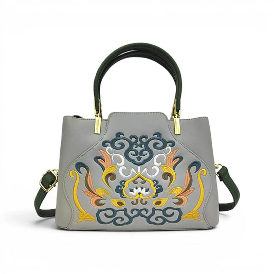 Grey leather handbag with elaborate traditional Chinese floral scroll embroidery, dark green top handle & detachable shoulder strap, polished gold metal hardware, studio shot on plain white background