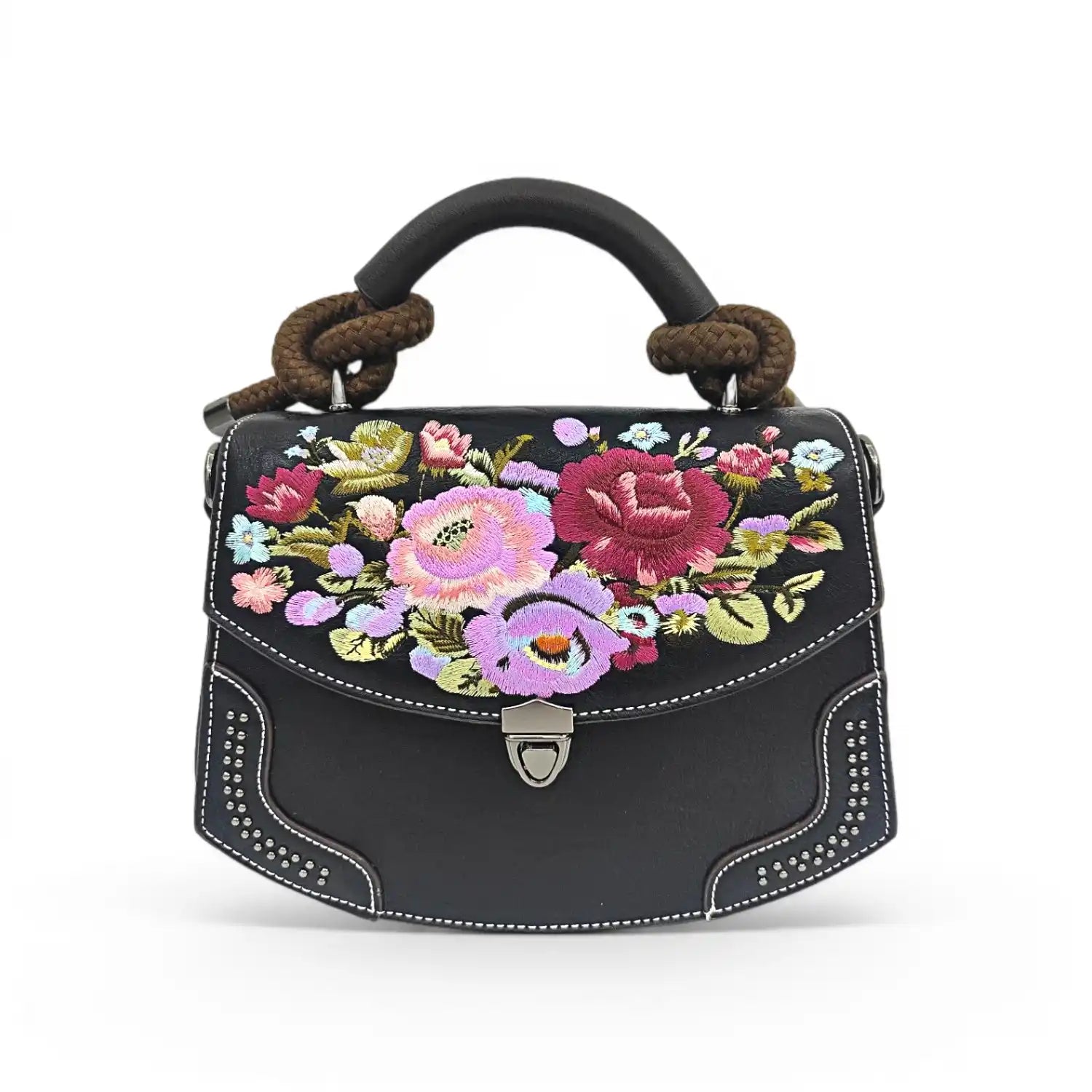 Black PU leather flap handbag decorated with colorful vintage wildflower embroidery, rivet trim and braided rope top handle, presented on a clean plain white background with retro metal turn-lock hardware.