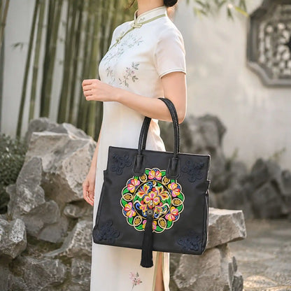 Black colorful embroidered tote paired with white cheongsam, modeled in traditional Chinese rock bamboo courtyard to show oriental formal outfit inspiration.