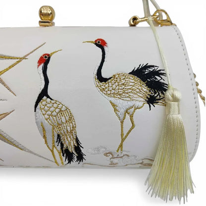 close‑up of red‑crowned crane embroidery and cream tassel detail on white chinese style handbag