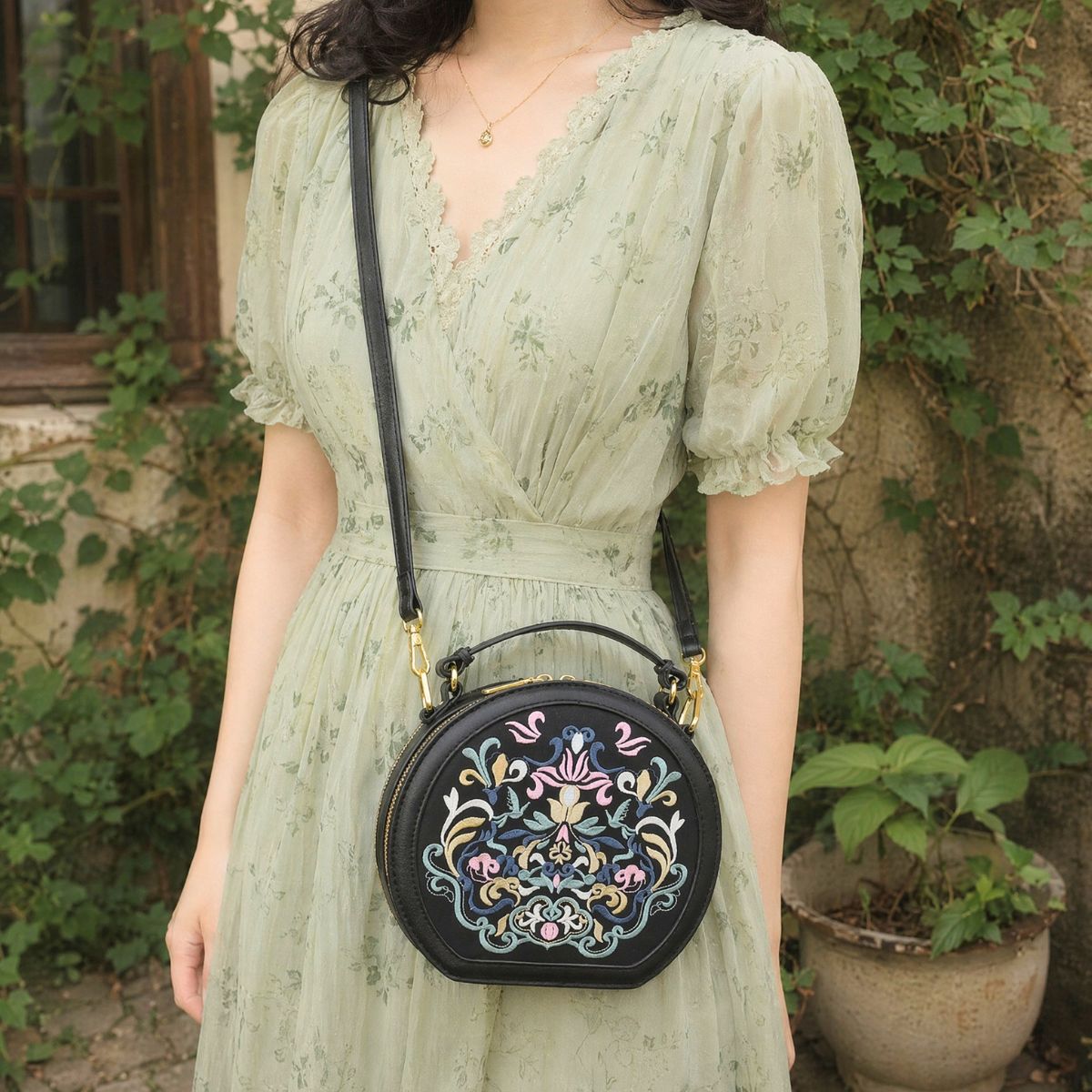 Young woman wears light green floral chiffon dress in retro vine courtyard, carrying black round handbag with elaborate traditional floral embroidery, gentle pastoral aesthetic style