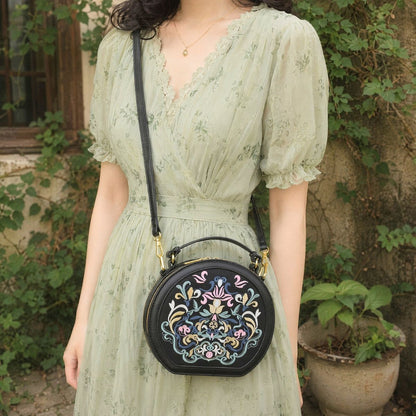 Young woman wears light green floral chiffon dress in retro vine courtyard, carrying black round handbag with elaborate traditional floral embroidery, gentle pastoral aesthetic style