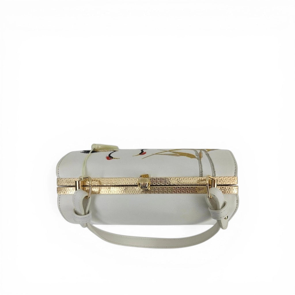 top view of white pu leather clutch bag with red‑crowned crane and golden bamboo embroidery, gold frame and short top handle