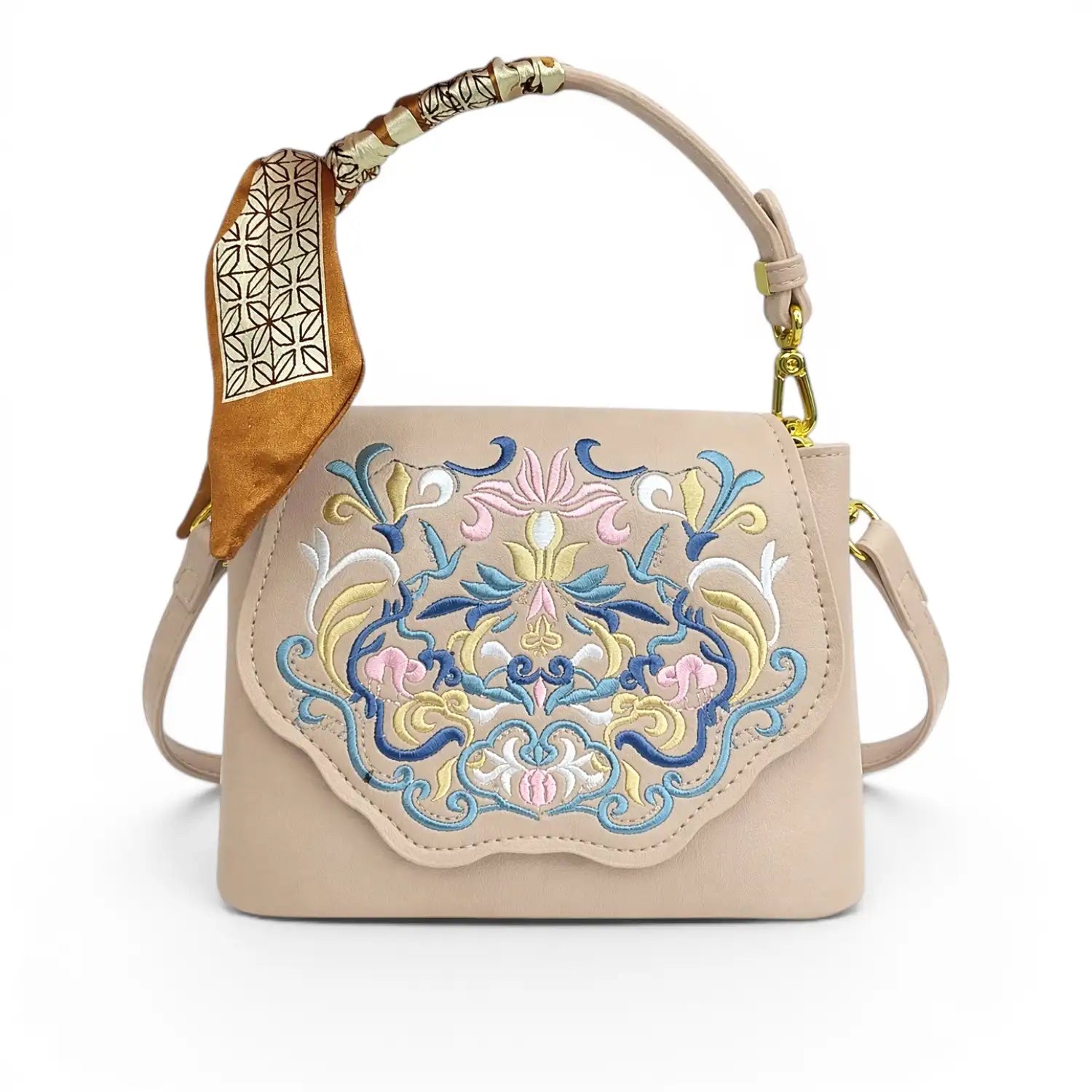 Beige leather crossbody handbag with traditional Chinese floral embroidery, printed silk scarf wrapped on top handle, golden hardware and detachable shoulder strap, product shot on plain white background